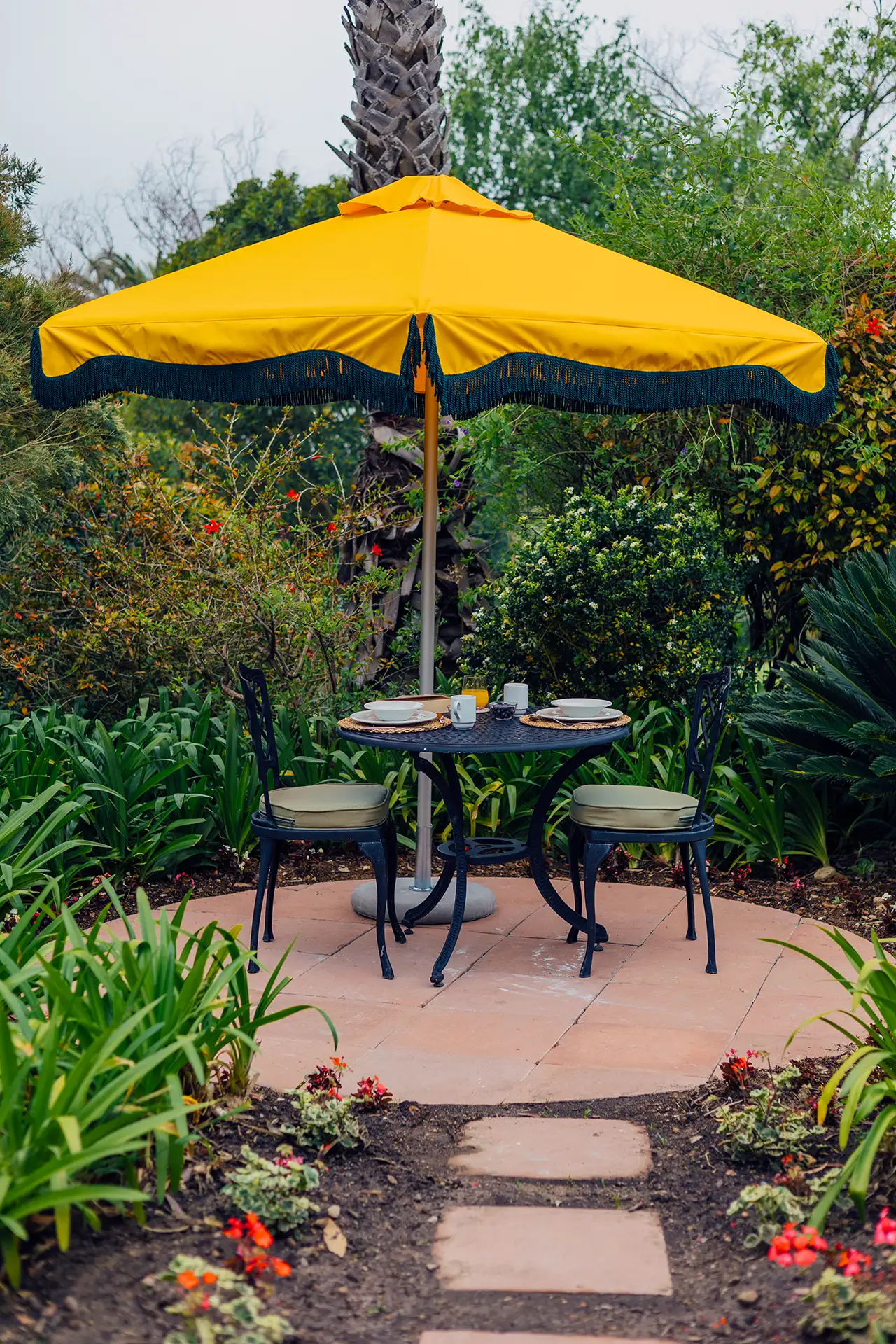 Yellow fringed parasol shading a bistro table